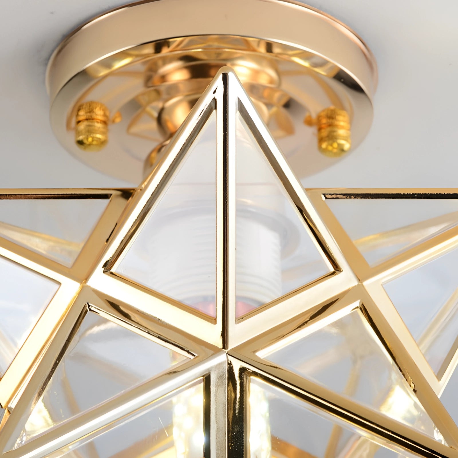Modern gold geometric star-shaped ceiling light fixture with an amber-colored shade, featuring wooden elements and luxury pendant design.