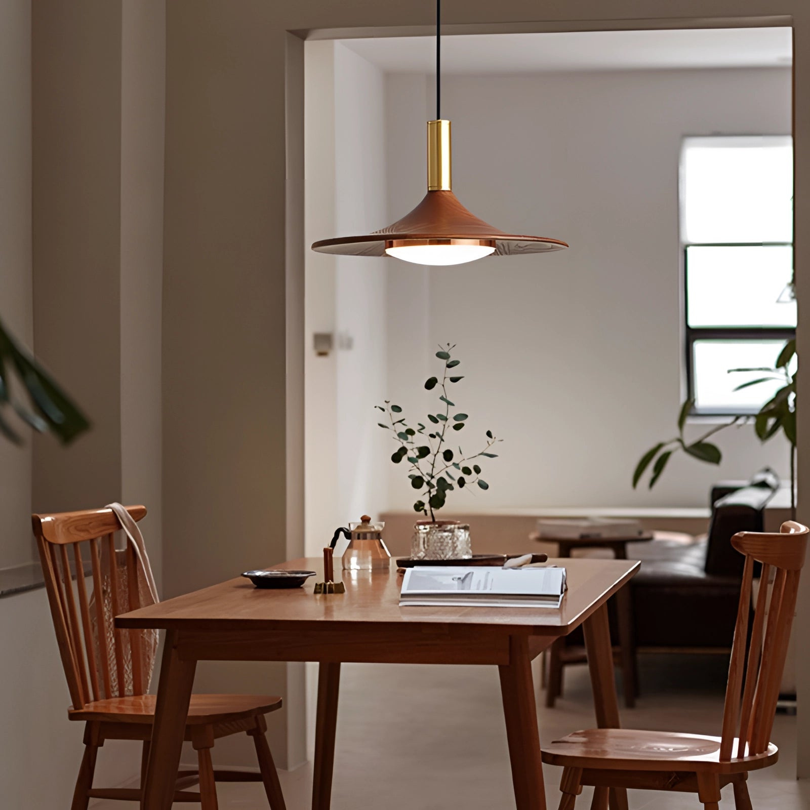 Modern gold LED pendant light with a Scandinavian luxury design, featuring a single light and third gear dimming, hanging above a contemporary interior space with wooden flooring and stylish furniture.