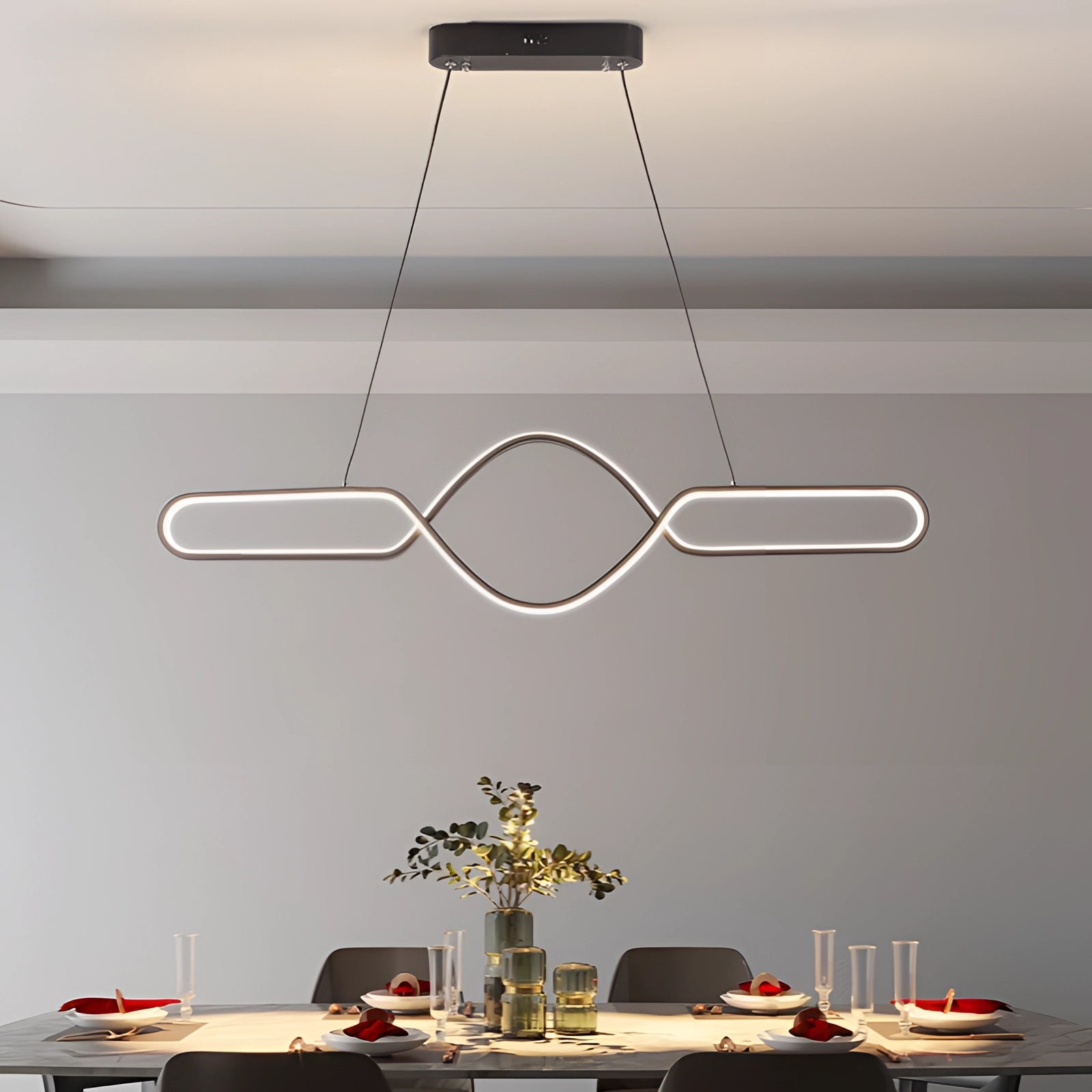 Modern gold LED pendant light with an adjustable infinity design in black, featuring a dimmable function and remote control, elegantly suspended above a contemporary furnished space.
