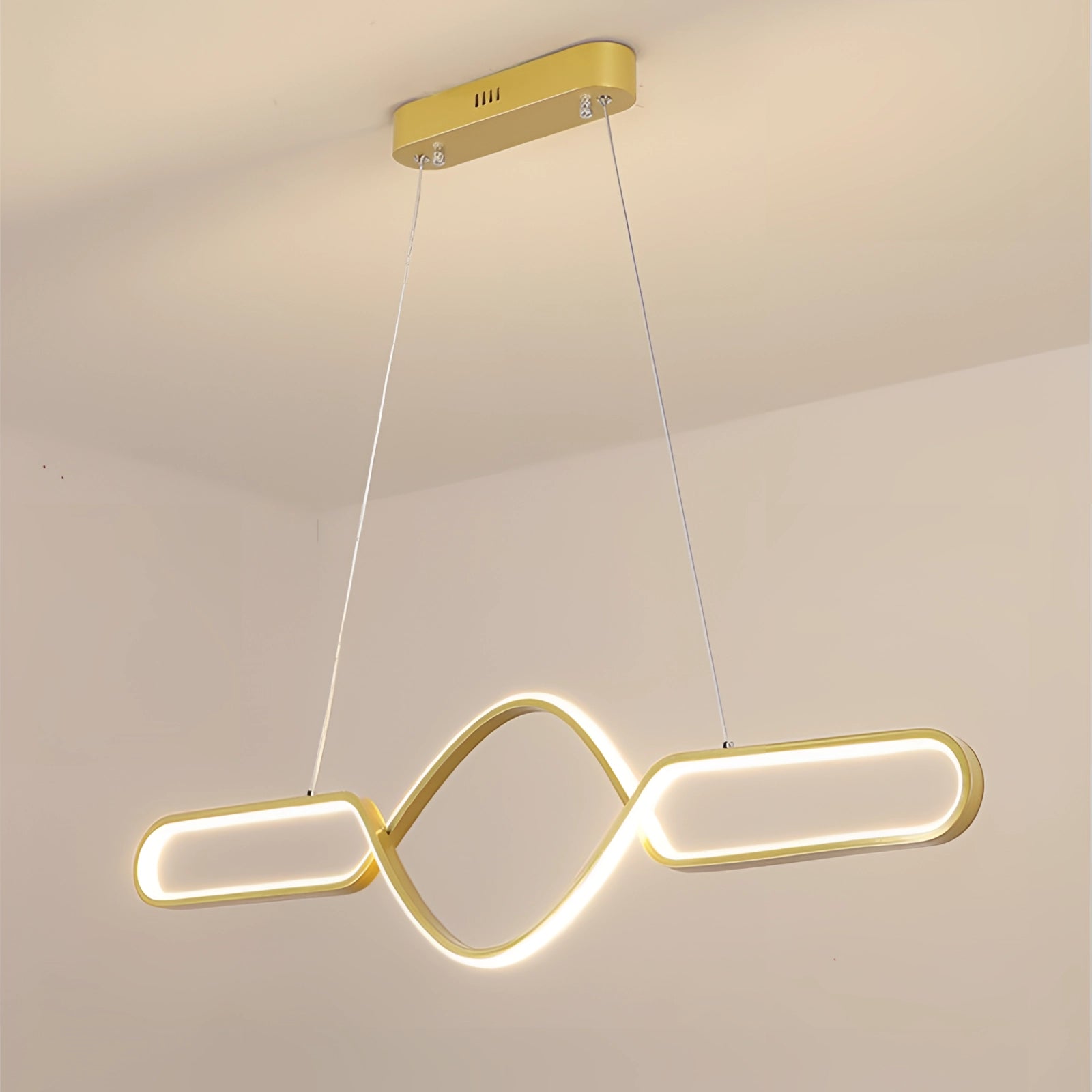 Modern gold LED pendant light with a luxury adjustable infinity design, featuring a sleek and contemporary aesthetic, suspended from a ceiling, emitting a warm amber glow.