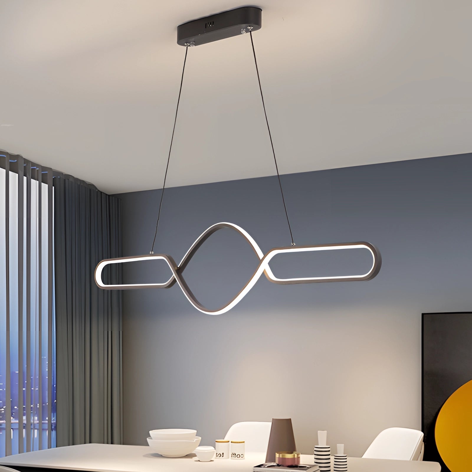 Modern gold LED pendant light with a luxury adjustable infinity design, featuring a sleek black and white color scheme, hanging stylishly above a wooden floor against a wall.