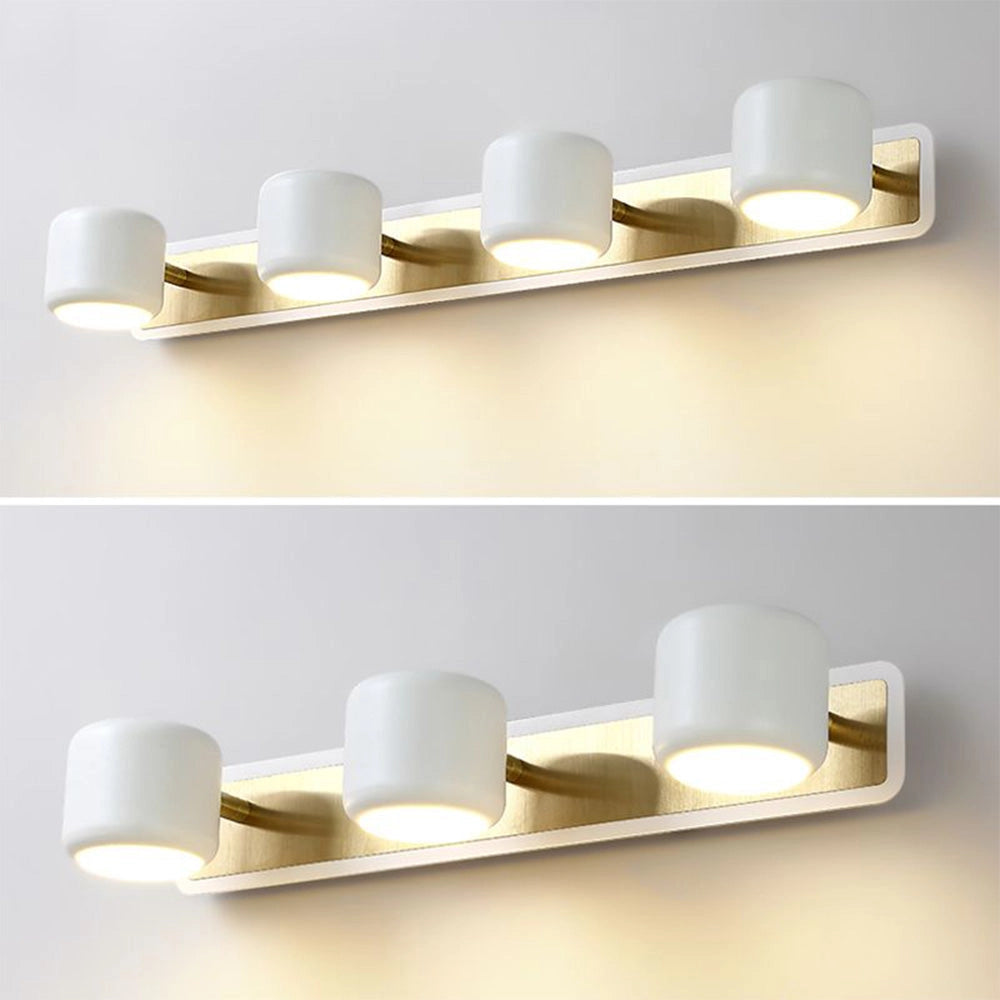 Modern gold LED vanity light fixture with a minimalist design, featuring five lights mounted on a rectangular base. The fixture is installed on a wall, and the gold finish adds a touch of elegance to a white-themed bathroom interior.