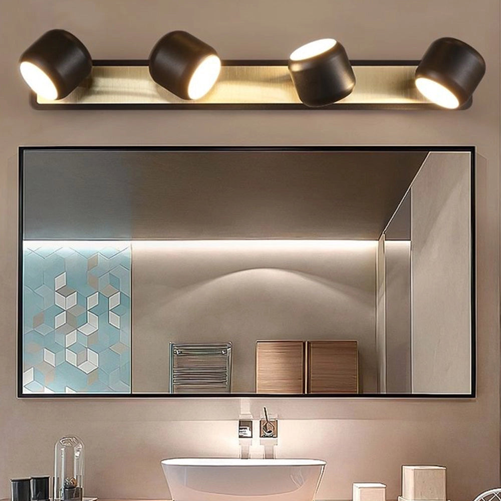 Modern gold LED vanity light with five minimalist lights mounted above a rectangular mirror in a bathroom setting, featuring white walls, a sink, and a faucet.