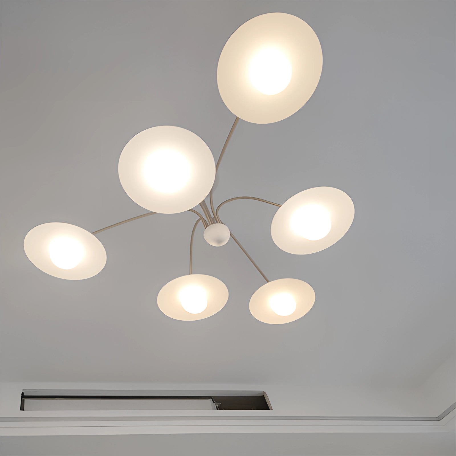 Modern gold opal glass mid-century chandelier with a circular design, featuring multiple spherical opal glass shades and gold accents, elegantly hanging from the ceiling in a stylish interior setting.