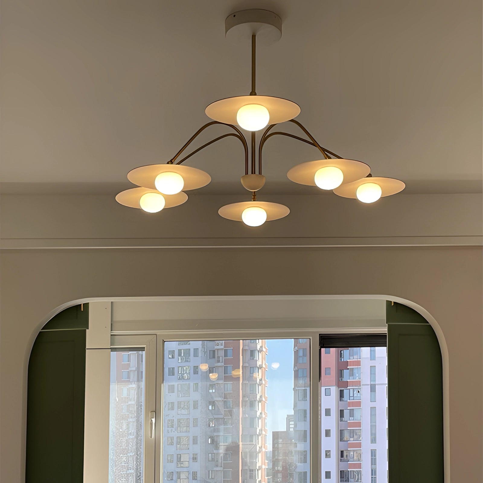 Modern gold opal glass mid-century chandelier with multiple arms and opal glass shades, hanging from the ceiling in an elegantly designed interior space, providing ambient lighting.