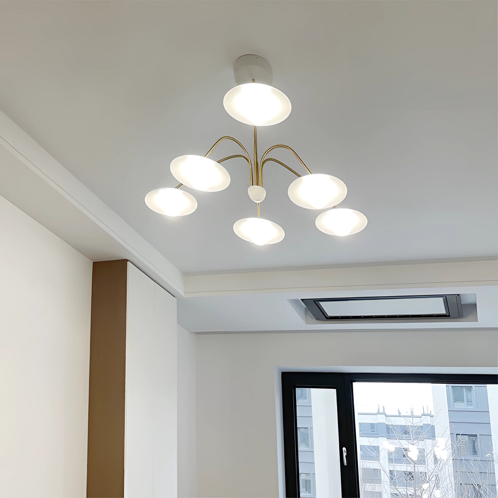 Modern gold opal glass mid-century chandelier hanging in an elegantly designed interior space, featuring multiple opal glass shades and a sleek gold fixture, enhancing the room's sophisticated décor.