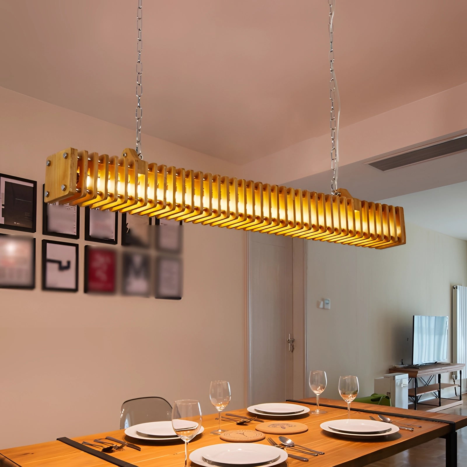 Modern gold pendant light hanging above a dining table set with tableware and dishware, showcasing a stylish interior design setting.