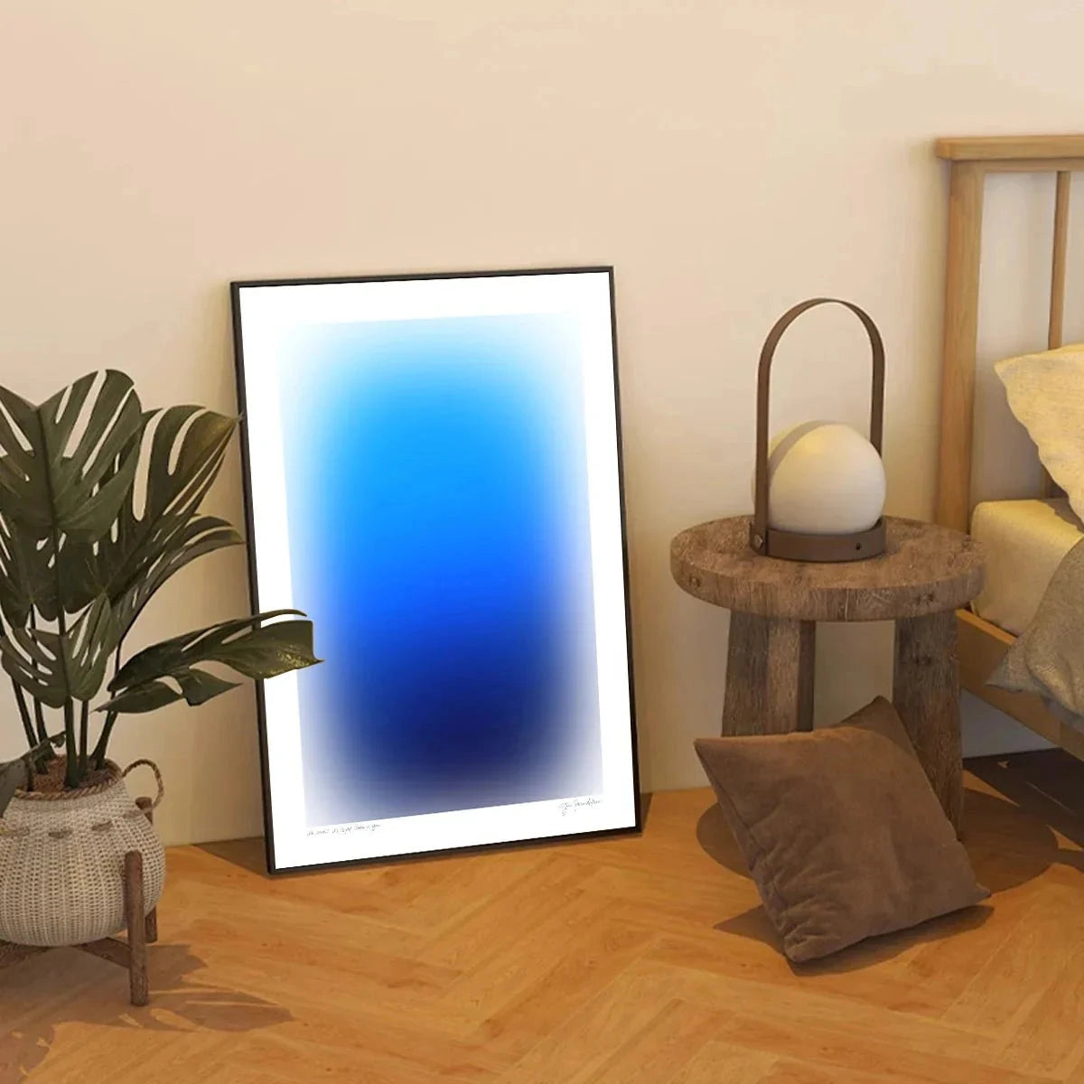 
A modern gradient wall art canvas featuring an orange and blue abstract design, styled in a minimalist decor setting with surrounding elements such as a wooden floor, a potted plant, and a lamp.