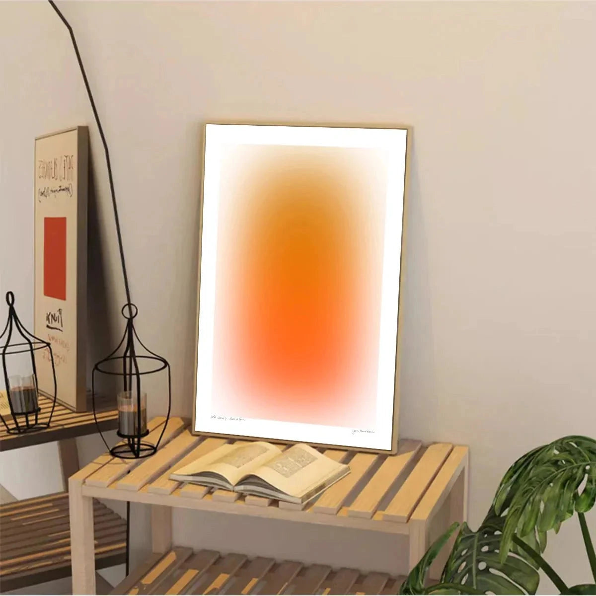 Modern gradient wall art featuring orange and blue tones on a rectangular canvas displayed in a minimalist interior setting with a wooden desk, a computer monitor, and a small plant nearby.