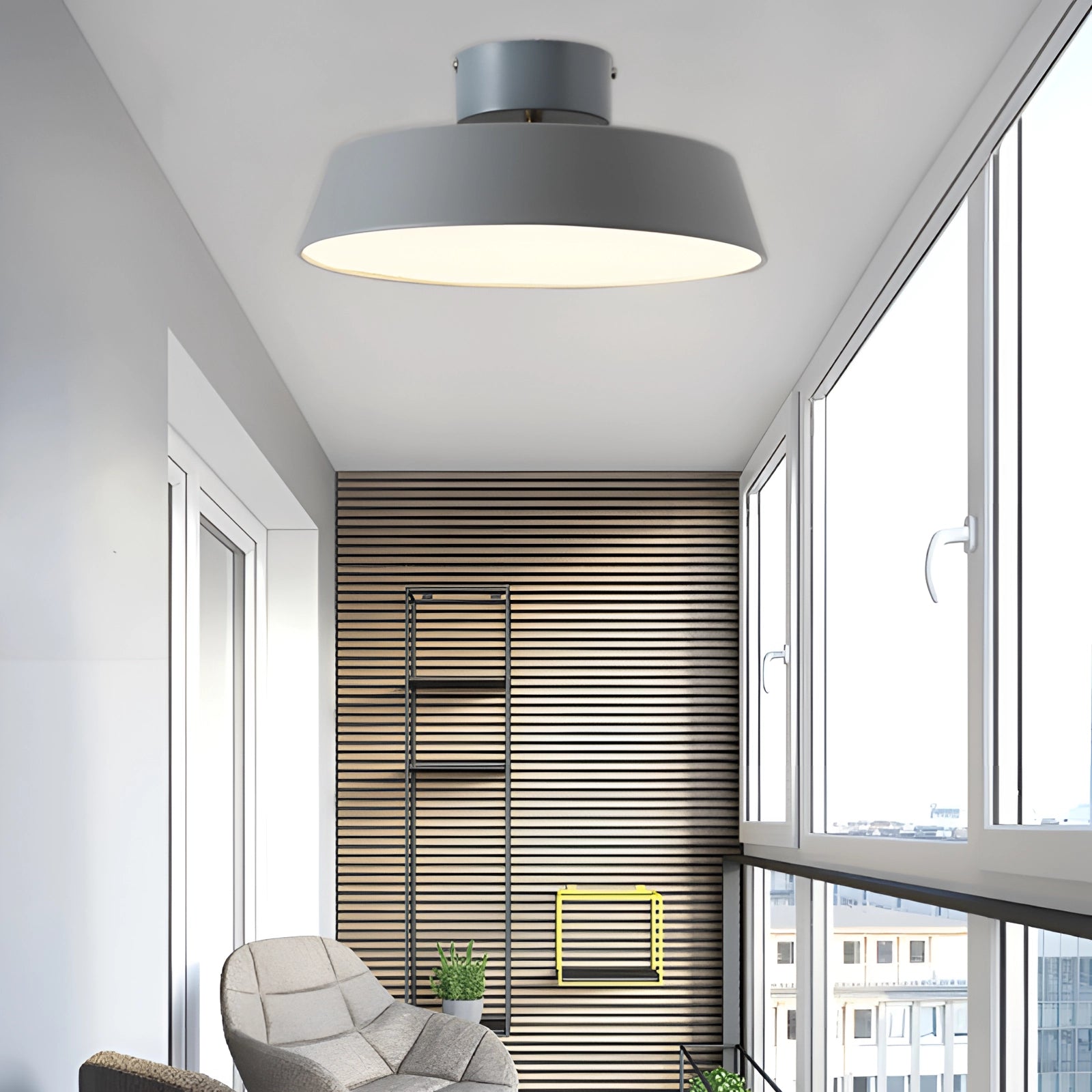 Modern grey LED pendant light with minimalist industrial design, hanging from the ceiling in a well-lit, contemporary interior.