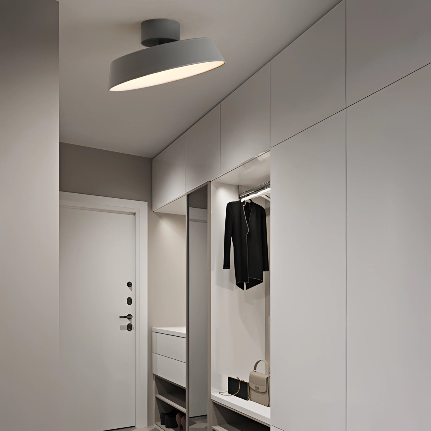 Modern grey LED pendant light with minimalist industrial design, hanging from a ceiling in a stylish interior space with sleek architectural elements.