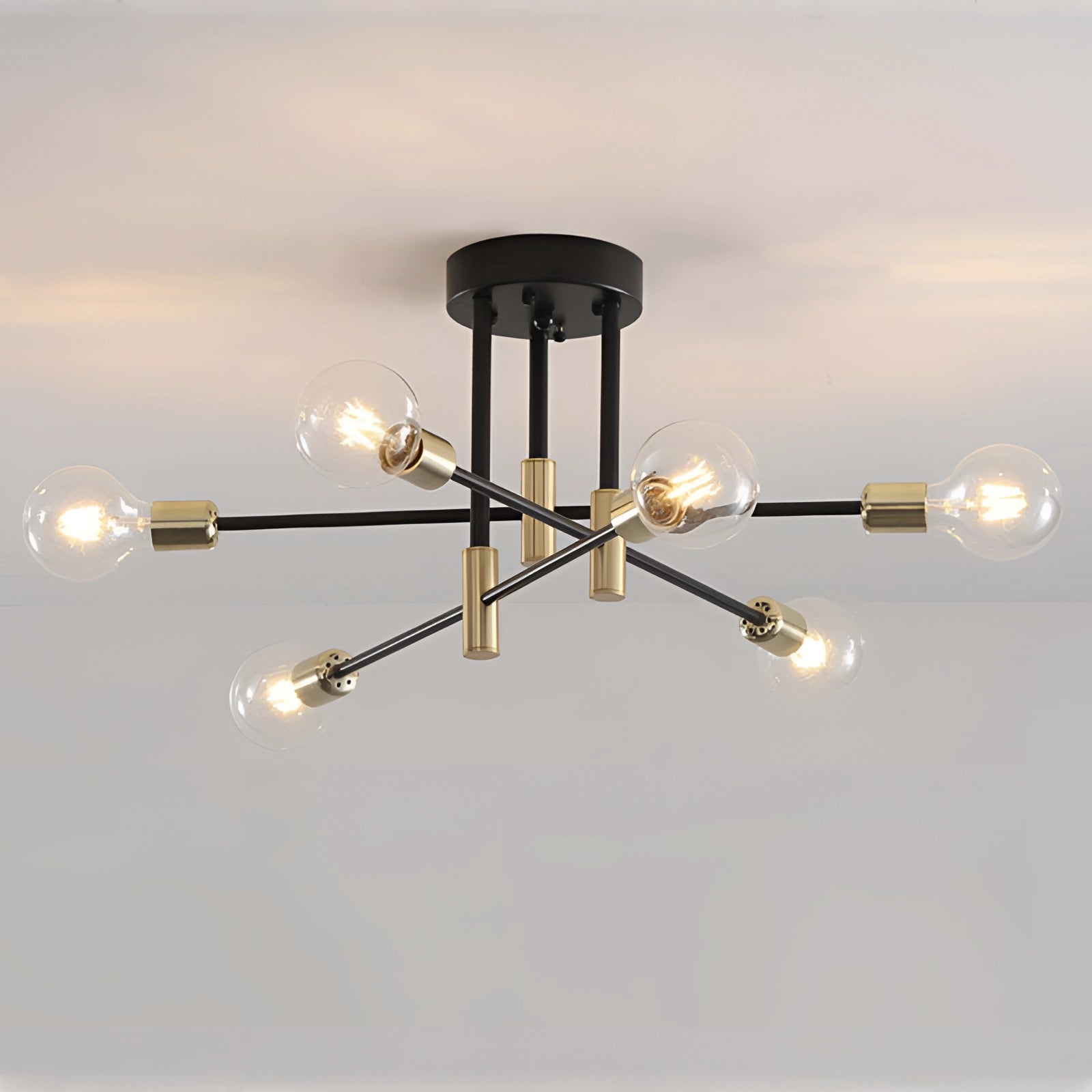 Stylish modern industrial 6-light pendant chandelier with brass and black metal finish, featuring a circular design, suspended from the ceiling.