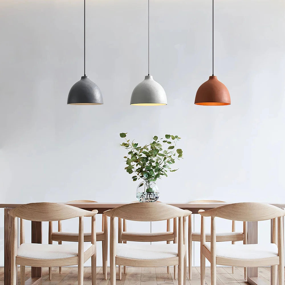 Modern industrial concrete pendant light with Scandinavian yellow accent hanging above a wooden table, showcasing stylish interior design.