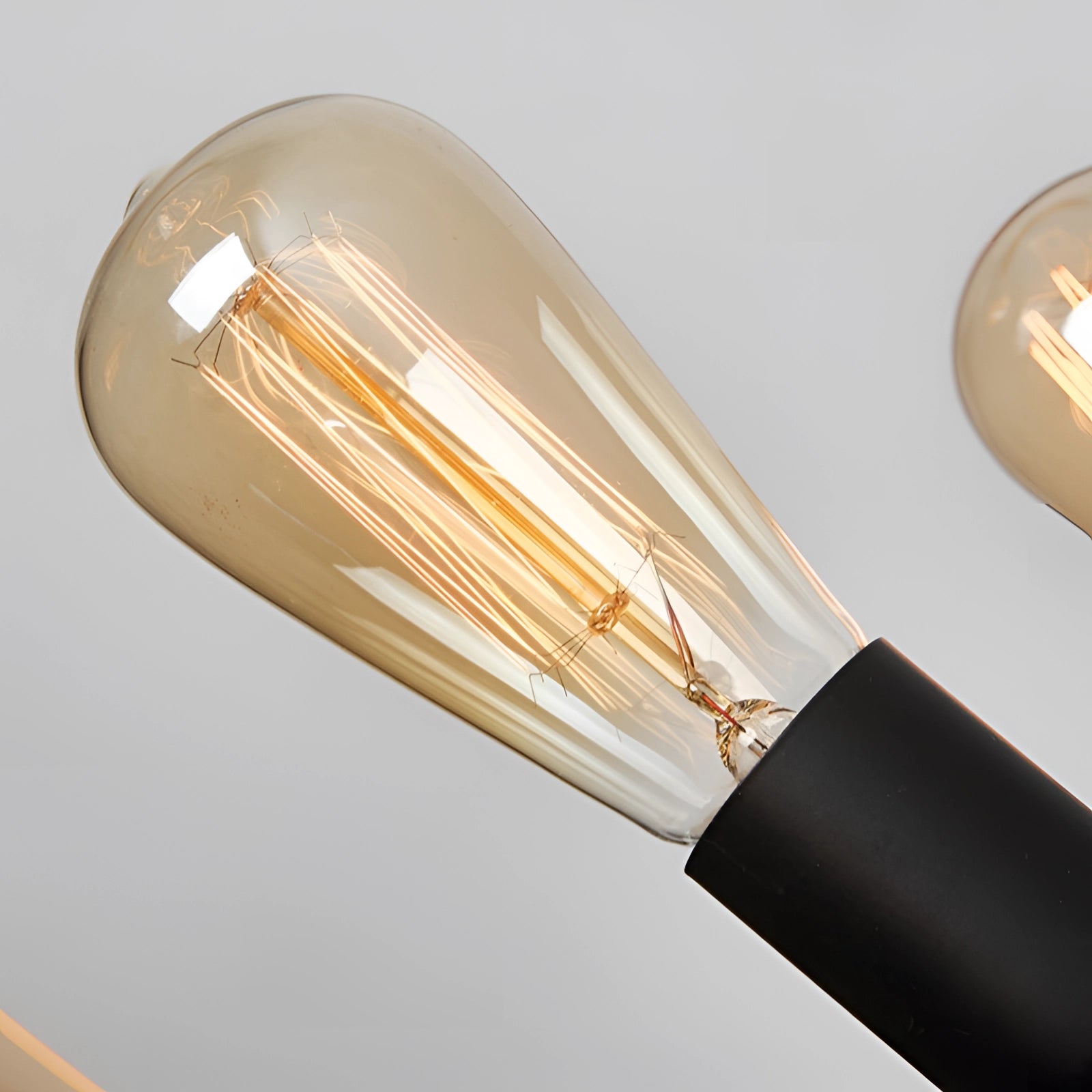 Modern industrial circular LED chandelier with multiple light bulbs, featuring a sleek metal design and amber lighting tones.