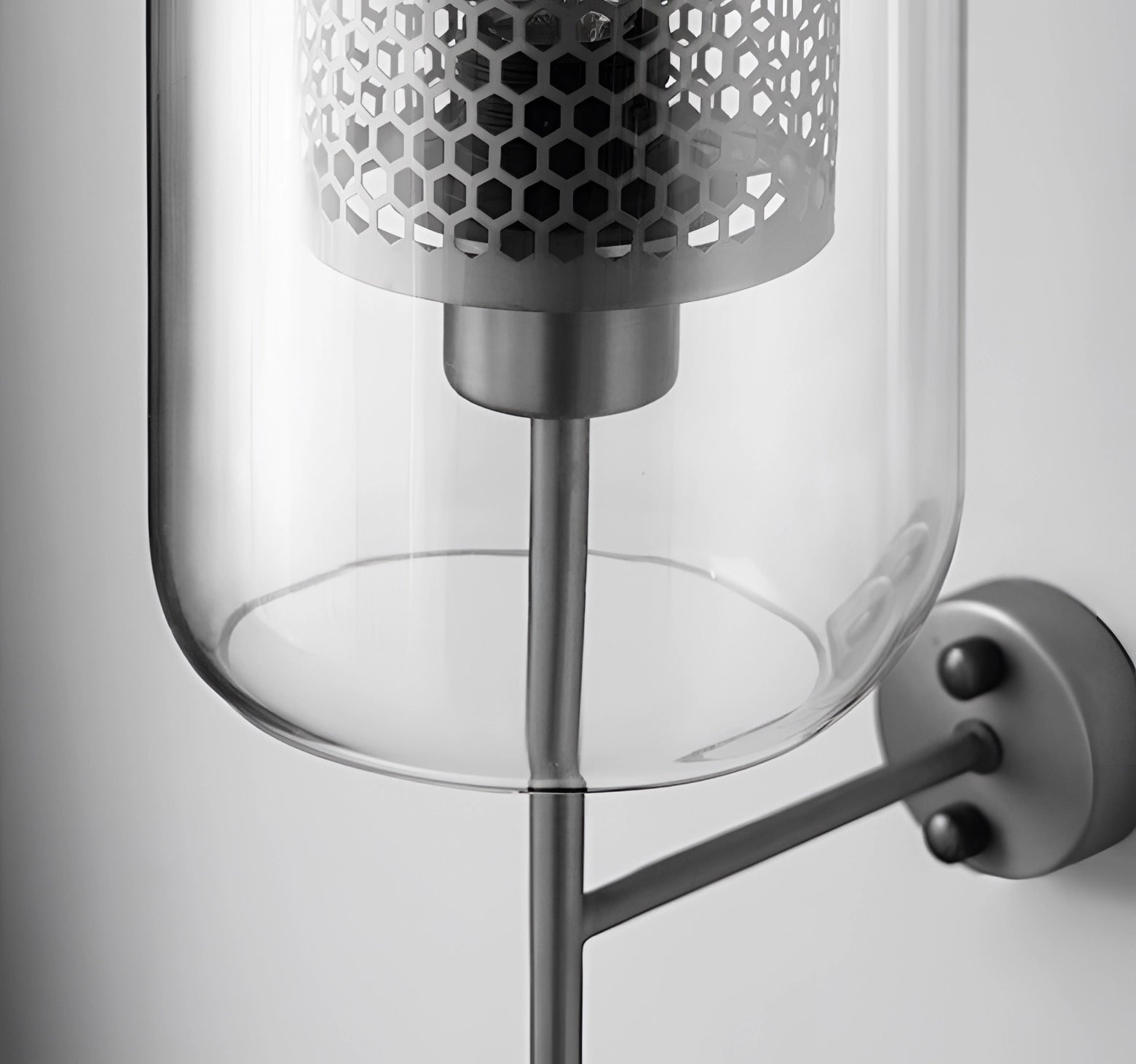 Modern industrial wall-mounted sconce with metal and glass light fixture, featuring a circular nickel design.