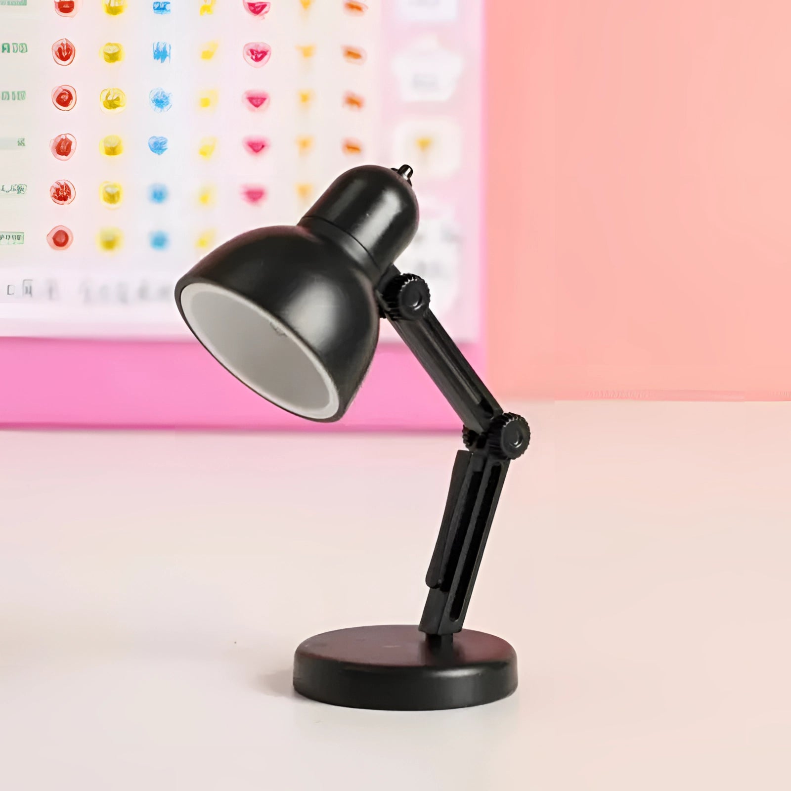 A modern LED black desk lamp with a sleek, minimalist design featuring an adjustable arm, placed on a wooden desk. The lamp has a compact structure, ideal for workspace illumination.