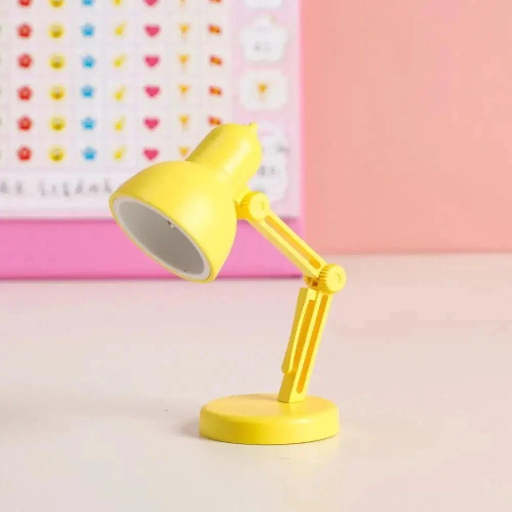 Modern LED black desk lamp with adjustable arm featuring a minimalist and compact design, predominantly in yellow, on a clean background.