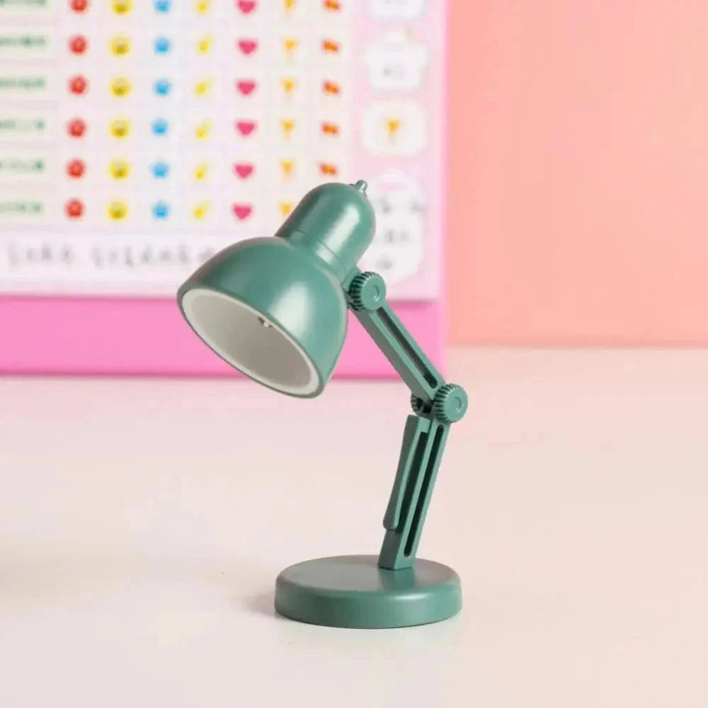 Modern LED black desk lamp with adjustable arm, featuring a minimalist and compact design in a green variant, set against a background with circular and magenta elements.