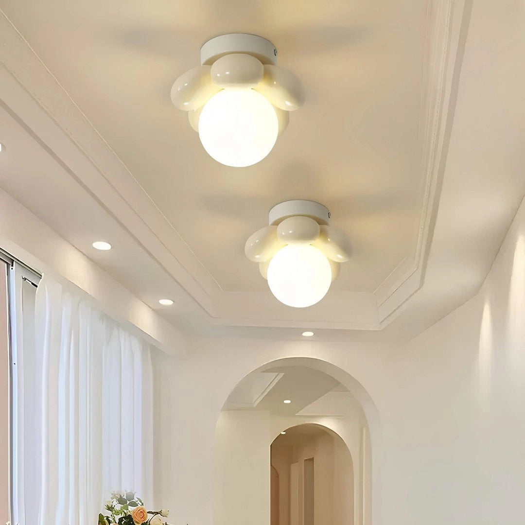 Modern LED ceiling light with a minimalist round flush mount design featuring opal glass, installed in an interior setting with wooden elements and curtains.
