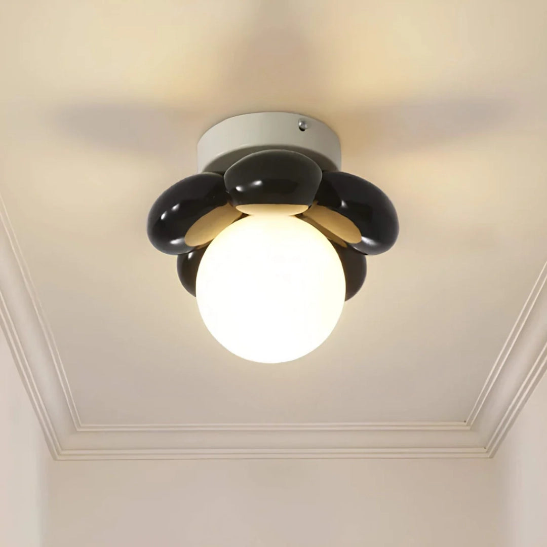 Modern black LED ceiling light with a minimalist round design, featuring a flush mount and opal glass shade, symmetrically mounted on a ceiling.