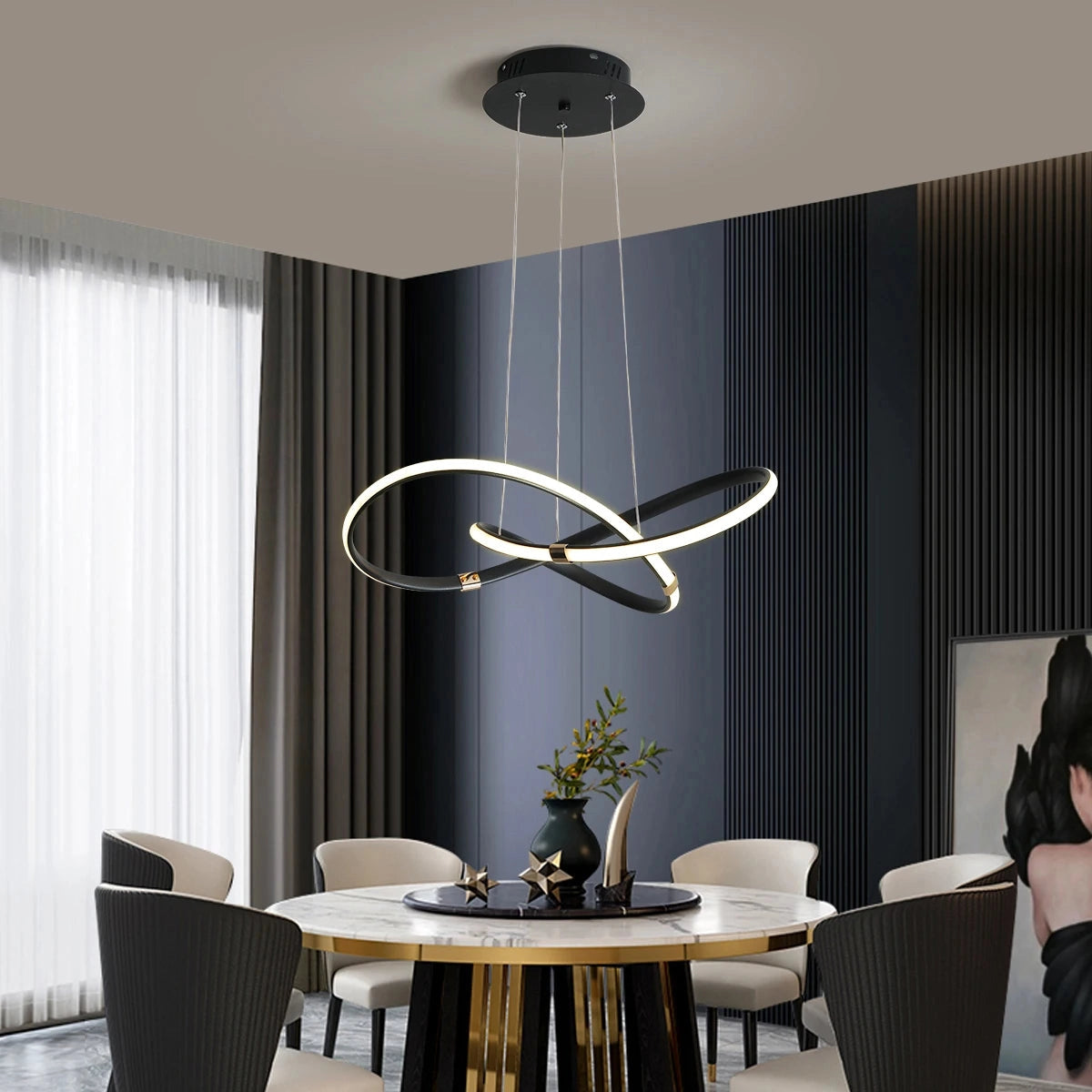 Modern LED chandelier with geometric pendant design hanging from the ceiling, illuminating a stylishly furnished room with table, chairs, and indoor plants.
