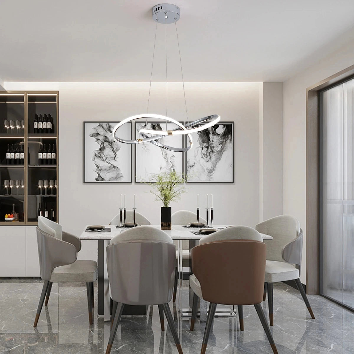 Modern silver geometric LED chandelier pendant light hanging from ceiling, illuminating a stylish interior with a table, chairs, and indoor plants.