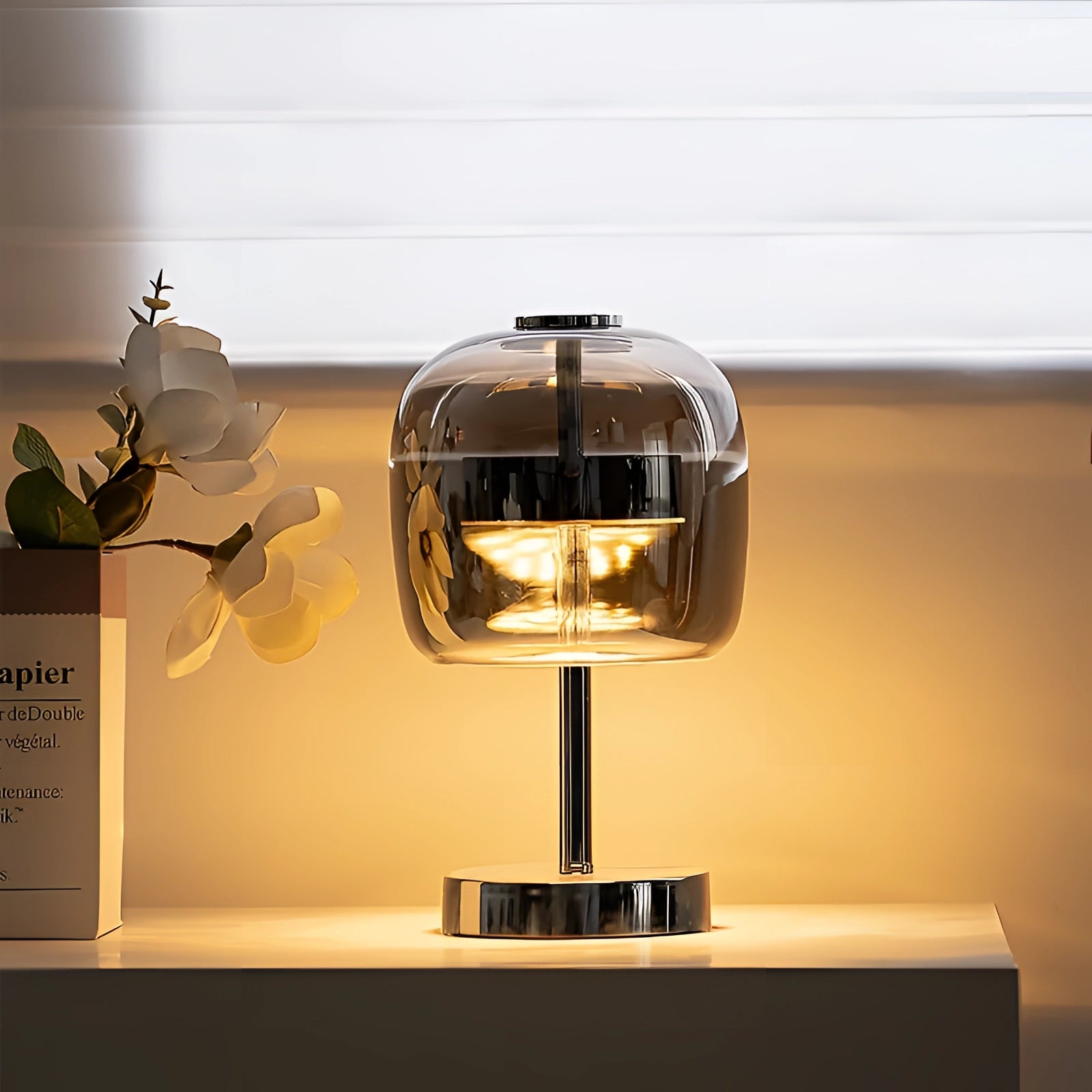Modern LED glass lamp featuring a sleek chrome base and a transparent shade, showcasing contemporary design elements with metal and glass materials.
