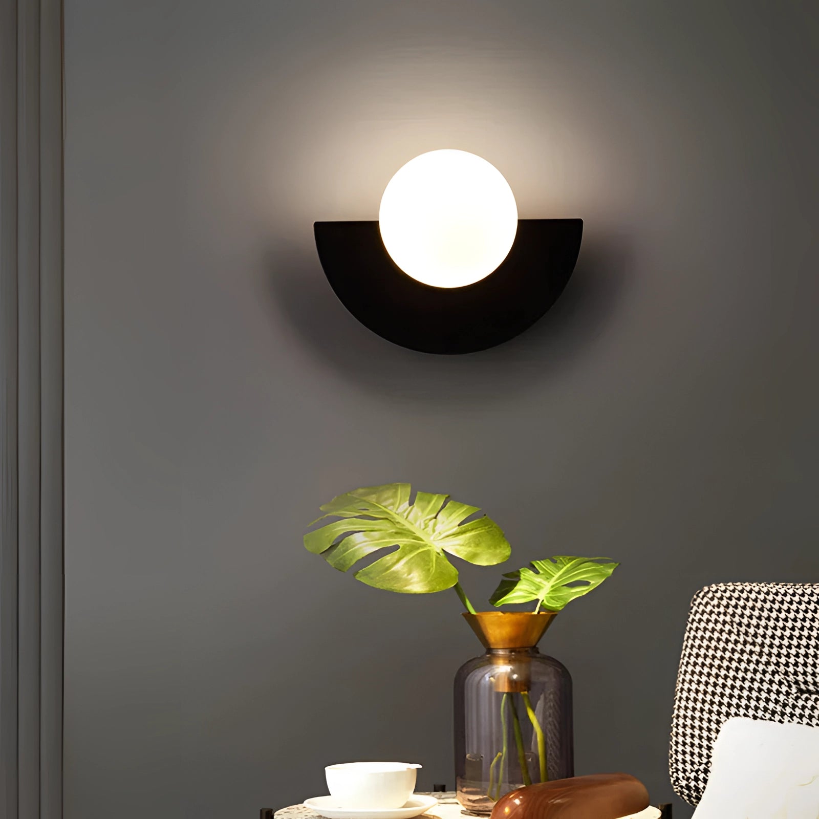 Modern LED half-moon wall light with a minimalist design, mounted on a wall in a living room setting, casting a soft glow and creating an elegant ambiance.