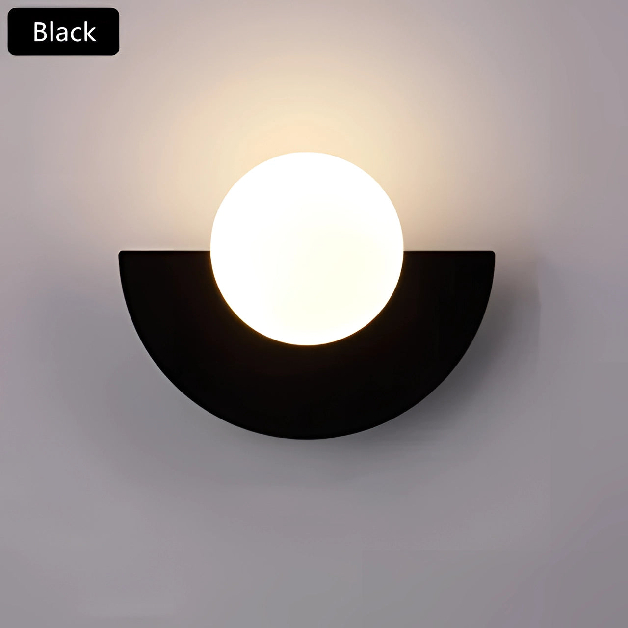 Sleek black modern LED half-moon wall light with a minimalist design, installed in a living room setting. The sconce emits three colors of light, creating an elegant and contemporary atmosphere.