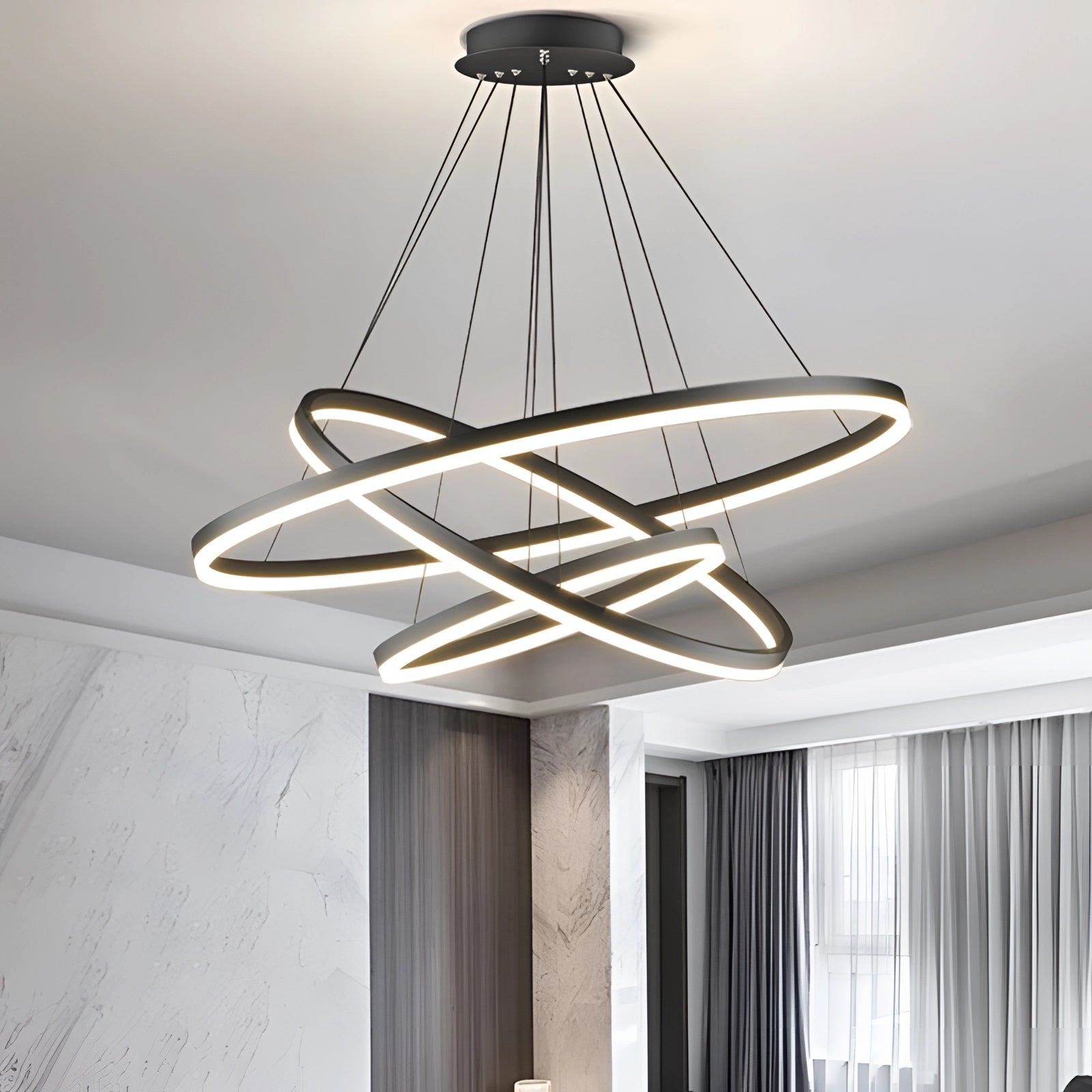 Modern LED pendant light with a circular chandelier featuring an orbit design, shown in a 12", 16", and 23.5" dimmable configuration, suspended from the ceiling in a contemporary interior setting.