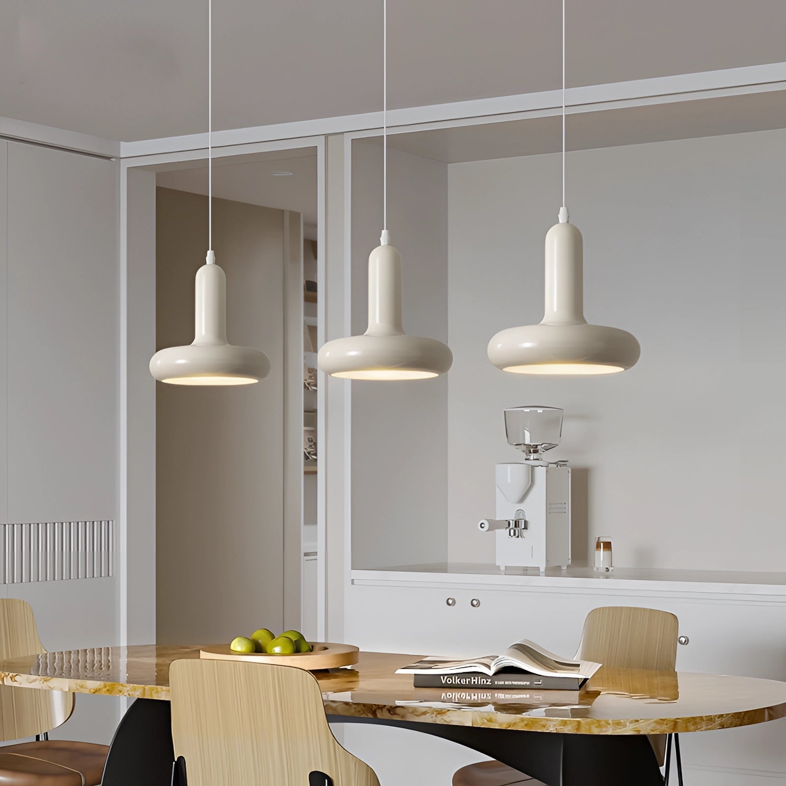 Modern LED pendant light with a Scandinavian minimalist design, illuminating a stylish kitchen and dining area. The scene includes a sleek white table, shelving units, and chairs, highlighting contemporary interior design elements.