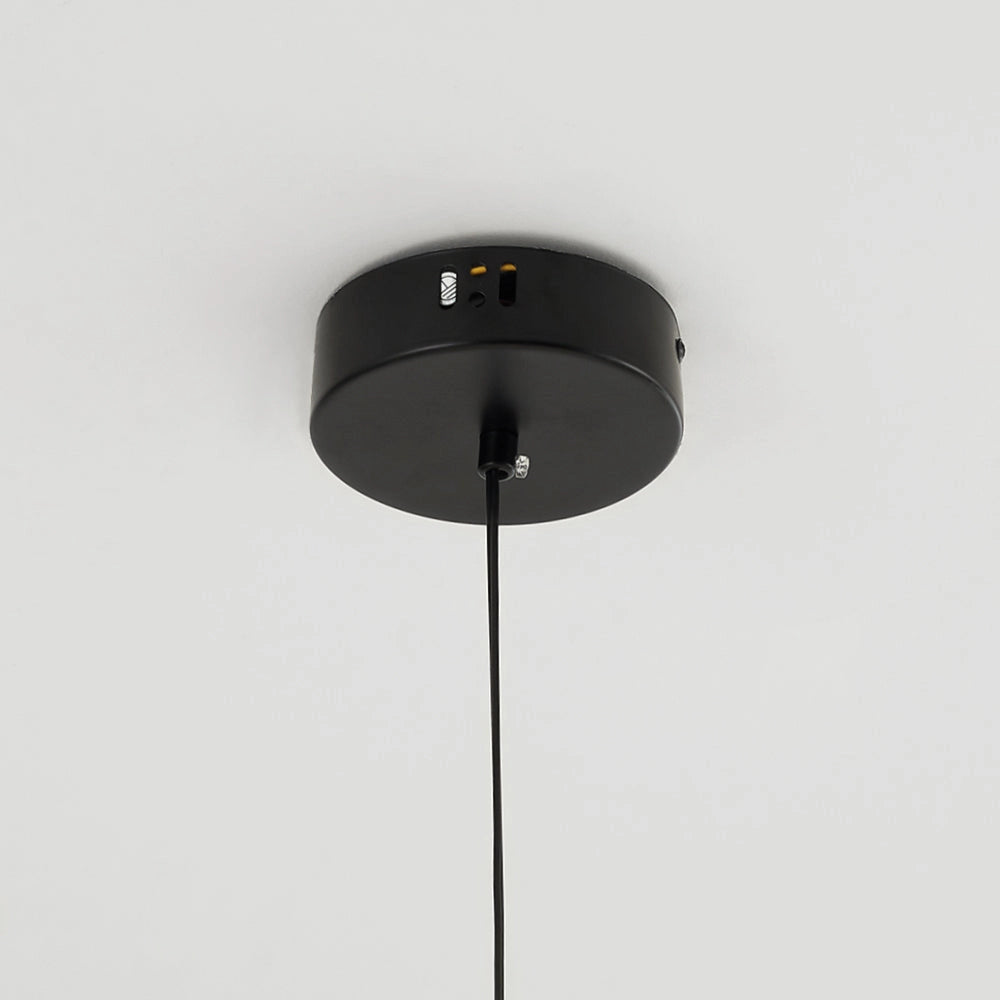 Modern LED pendant light in a sculptural design, featuring a white finish, hanging from the ceiling and illuminating the surrounding area.