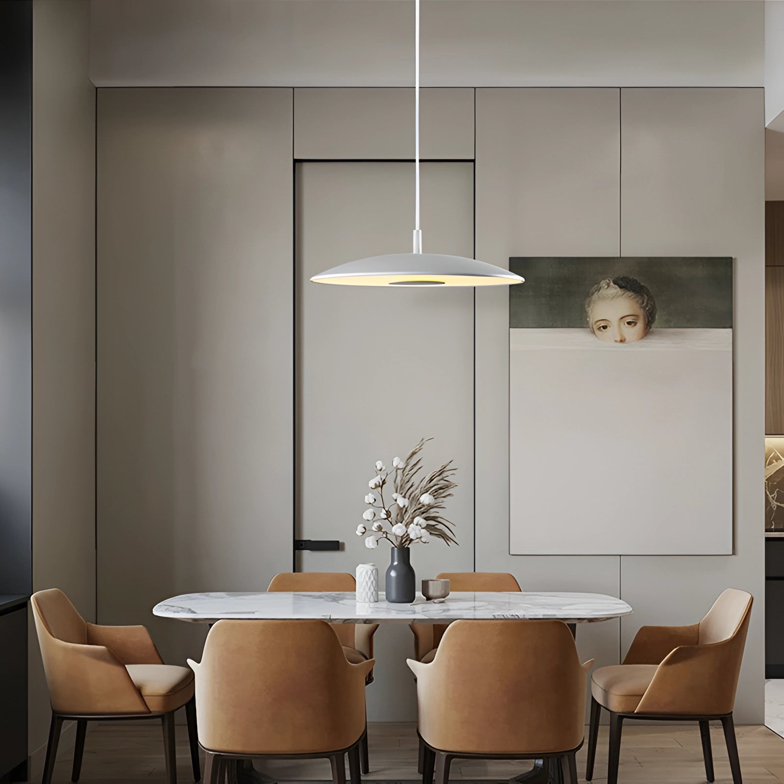 Modern LED pendant lights in stylish silver hanging above a wooden dining table with chairs, complementing the interior design with plants and a well-decorated wall in the background.