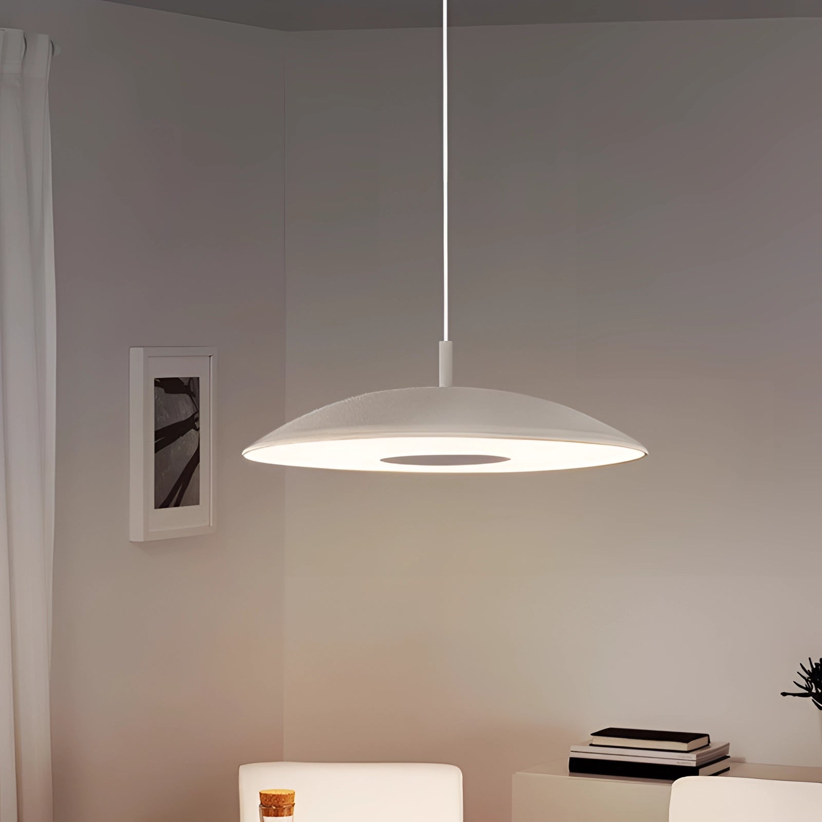 Modern LED pendant lights in a stylish silver finish hanging over a wooden dining table, complemented by houseplants and flowerpots.