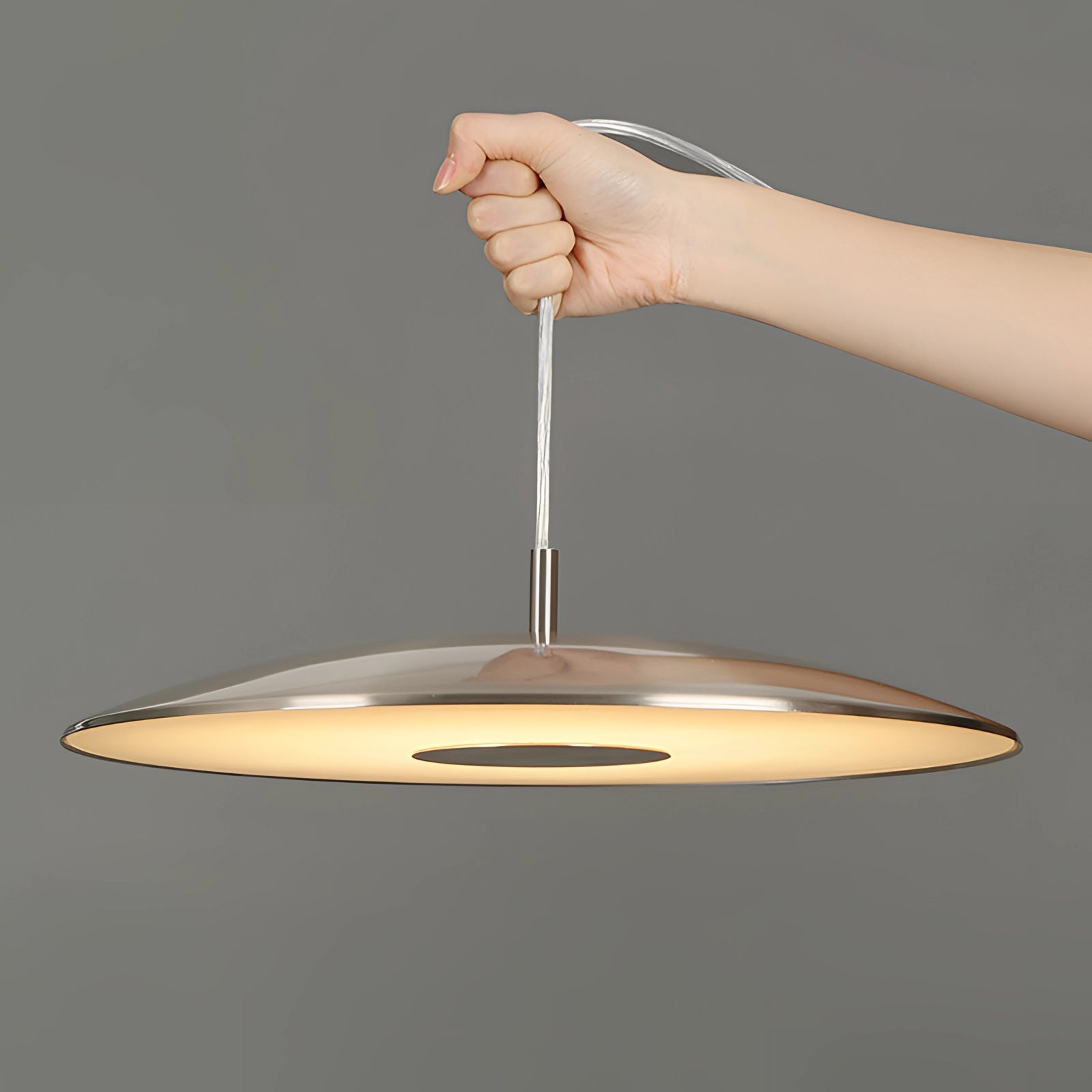 Modern LED pendant lights in stylish silver finish hanging over a wooden dining table.
