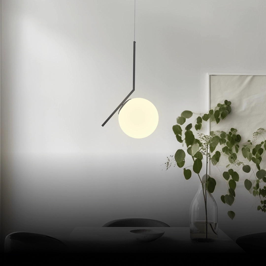 Modern LED round bedside lamp in black, featuring a minimalist design with cold white light. The lamp is pictured in a contemporary setting, with wall art and decor elements like a twig and plant nearby, enhancing the stylish ambiance.
