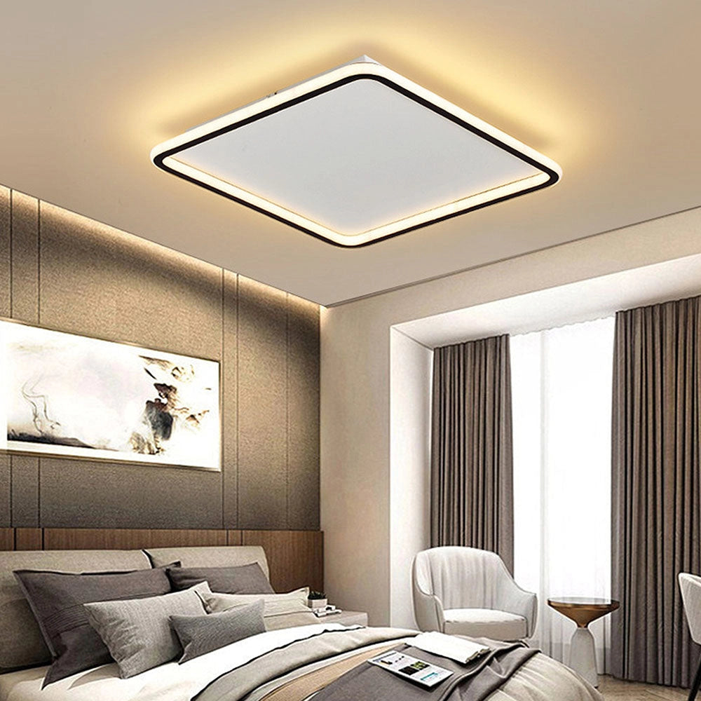 Modern LED square flush mount ceiling light with warm light, 50cm size, illuminating a stylish bedroom with white and wooden furniture.
