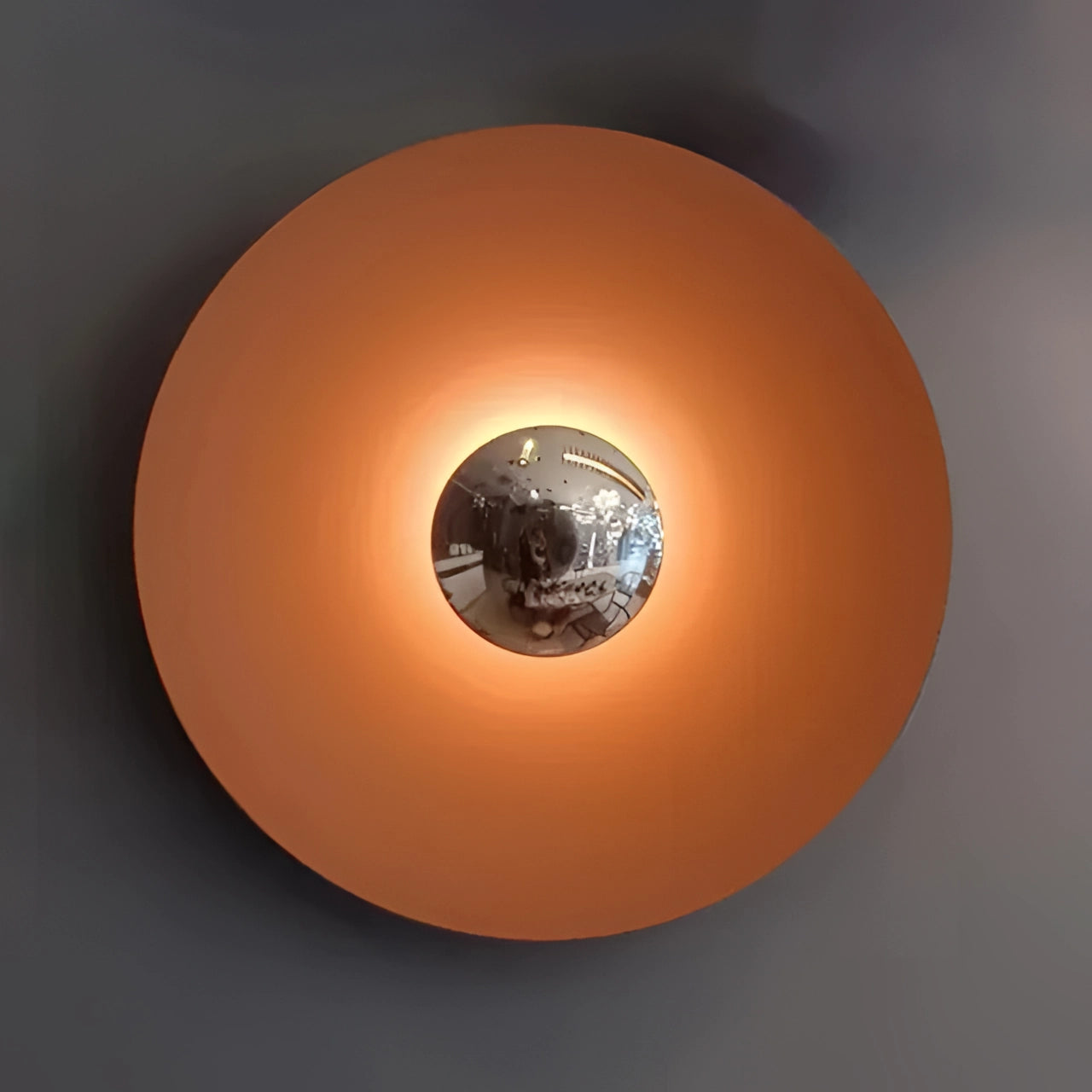 Modern LED wall lamp with a minimalistic brass design, featuring an orange and silver color scheme. The lamp is 60cm in length and emits a cold white light. The design includes circular and spherical elements, resembling a decorative art piece. The combination of metal and amber-like shades gives it a sophisticated and contemporary appearance, suitable for stylish home decor.