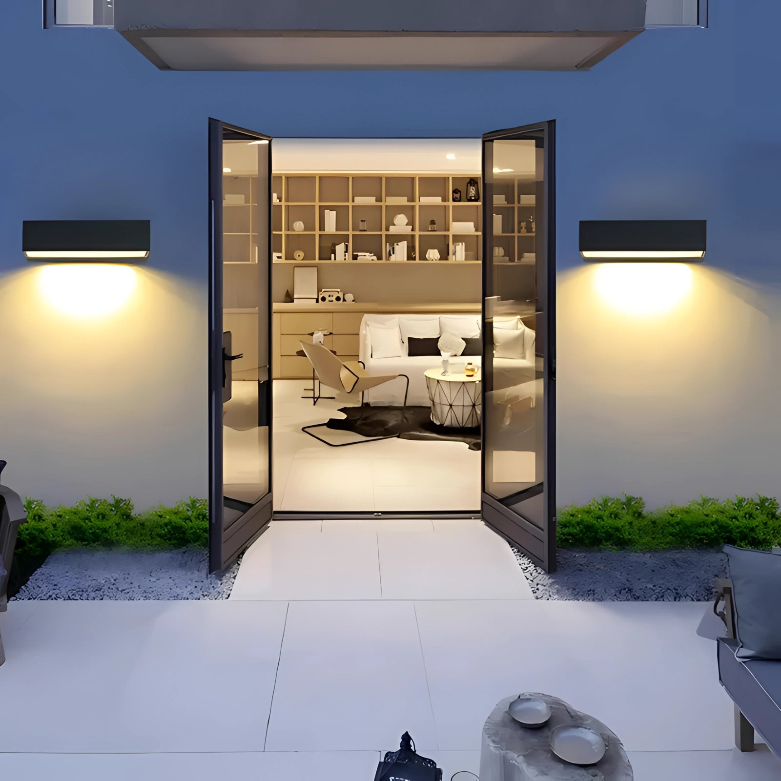 Modern LED wall light with a sleek black design, mounted on a wall in a stylish interior setting. The sconce is complementing the minimalistic decor which includes subtle plant elements and contemporary flooring.