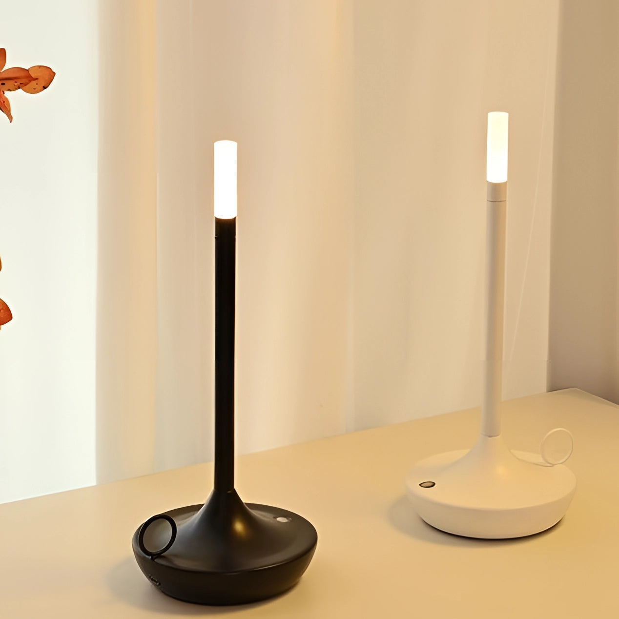 Modern luxury metallic candle holders on a table with a butterfly perched on one of them.