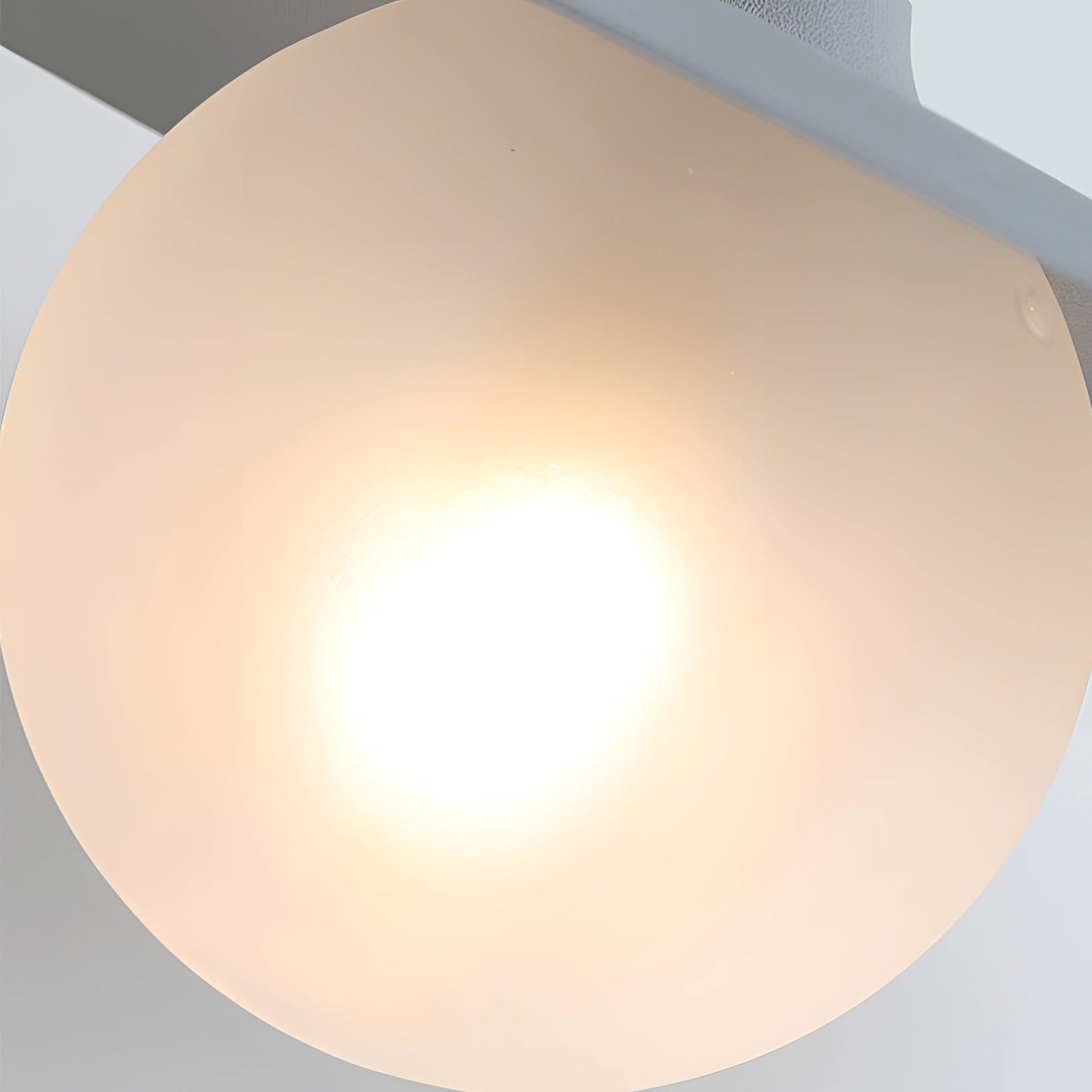 Modern matte black minimalist wall sconce mounted on a wall, featuring a circular design with a sleek lampshade, ideal for bedroom and hallway lighting.