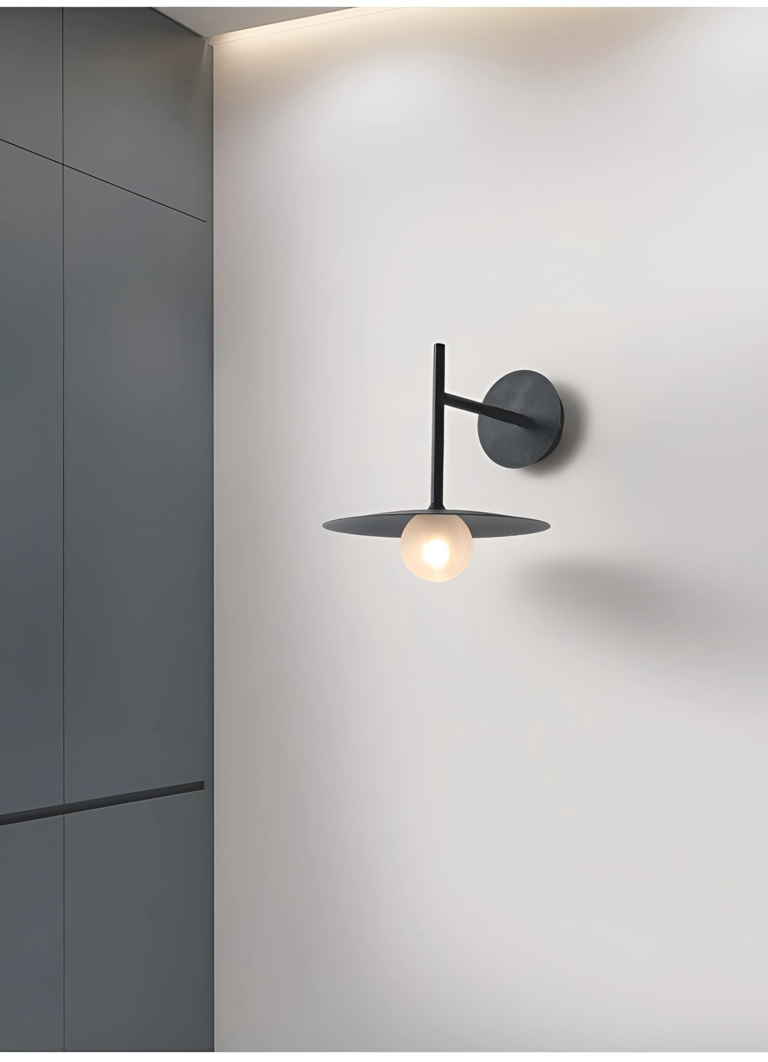 Modern matte black minimalist wall sconce mounted on a wooden wall, featuring a sleek rectangular design, ideal for bedroom and hallway lighting.