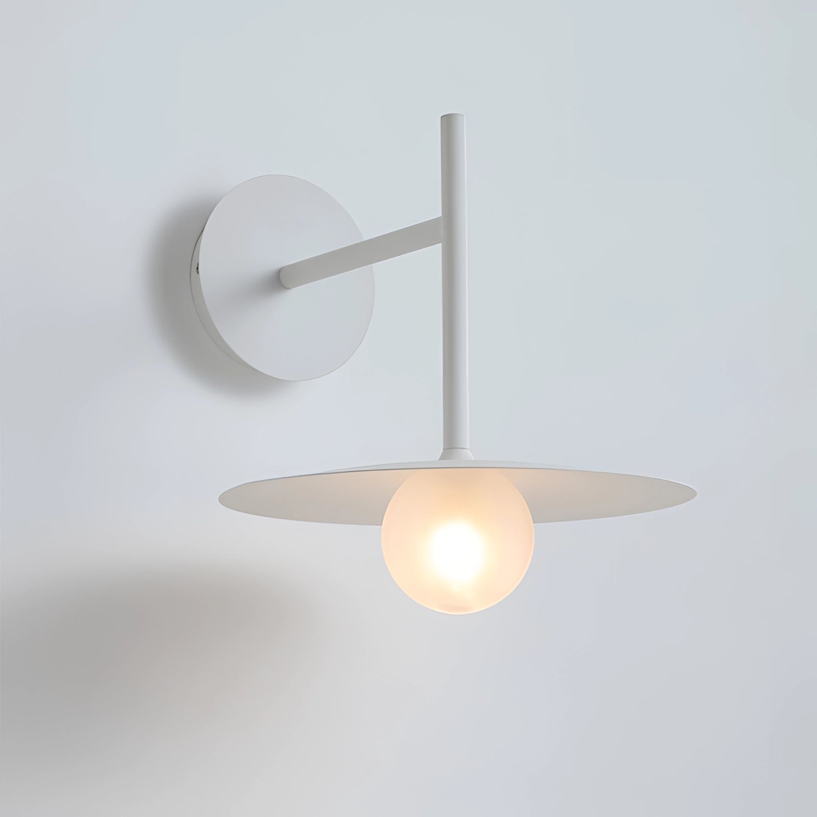 Sleek matte black wall sconce with a minimalist design, featuring a circular metal shade and wooden accents, ideal for bedroom and hallway lighting.