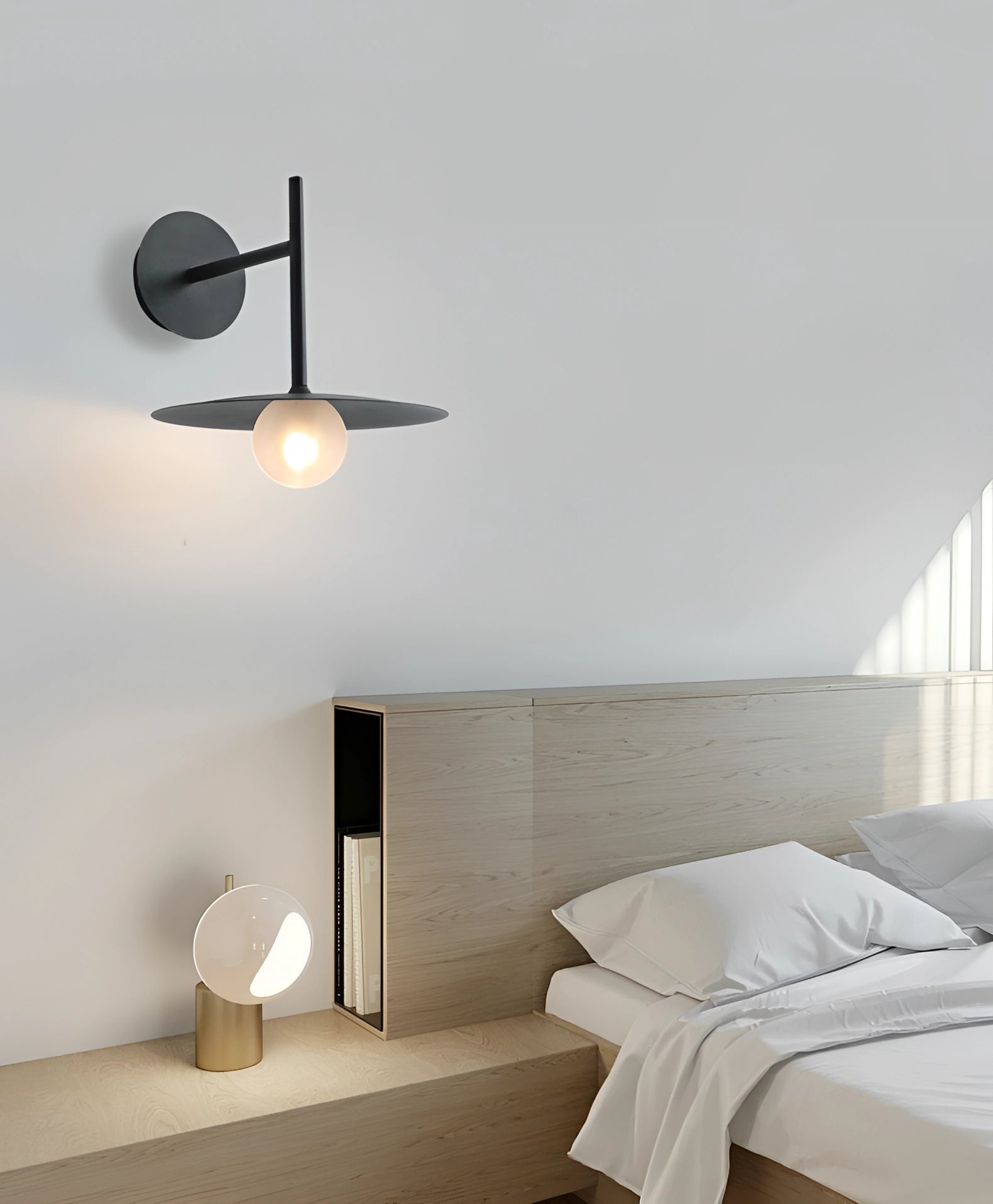Modern matte black minimalist wall sconce mounted on a bedroom wall, illuminating the space with its sleek design, complementing the contemporary interior with wooden accents and a bed frame in view.