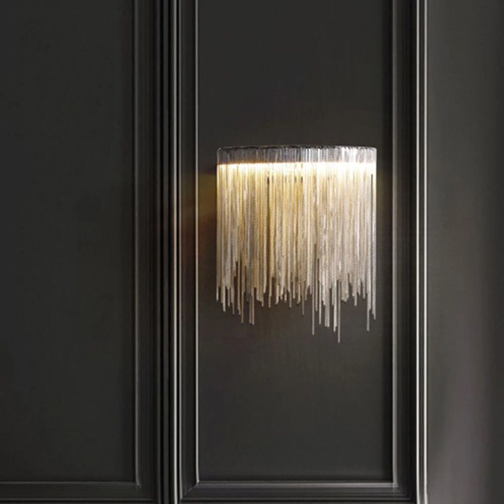 Modern metallic fringe chandelier with a contemporary design, featuring a luxurious ceiling light fixture. The chandelier incorporates elements of wood and metal, and is framed within a rectangular structure, casting elegant tints and shades in the surrounding space.