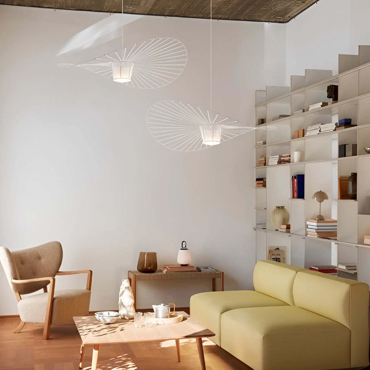 Modern minimalist ceiling fan with silent wing-shaped design installed in a bright and airy living room featuring a beige couch, white walls, and wooden furniture, creating a harmonious and contemporary interior design.