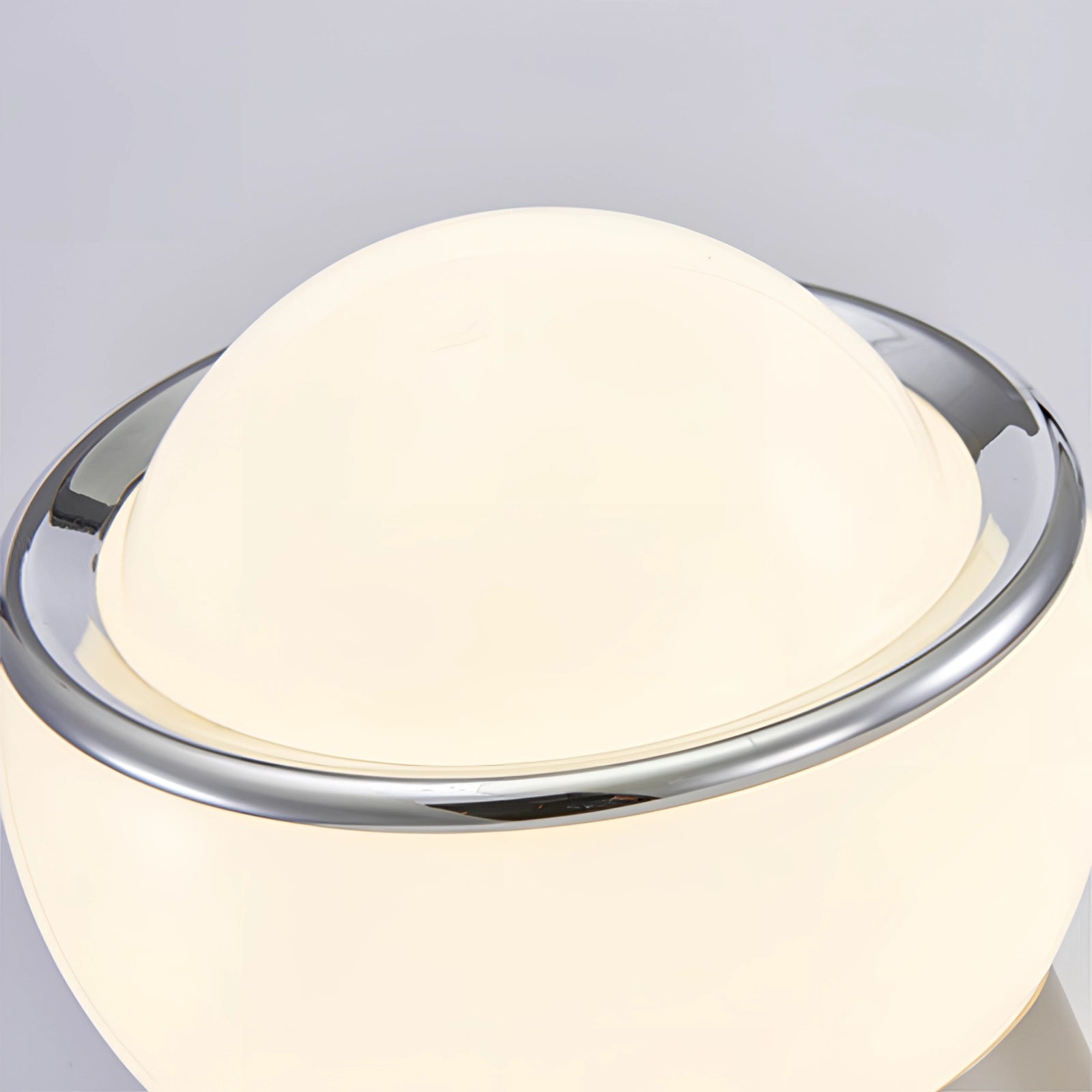 Modern Minimalist Circular LED Bedside Lamp with Sleek Metallic Base on a Beige Table.