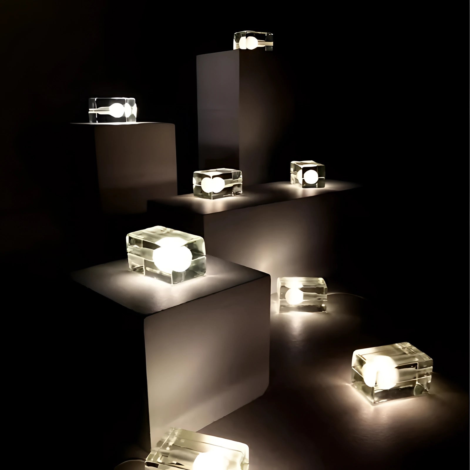 Modern minimalist clear glass cube table lamp with a sleek black base, showcasing a rectangular design that adds a touch of contemporary art to any room.
