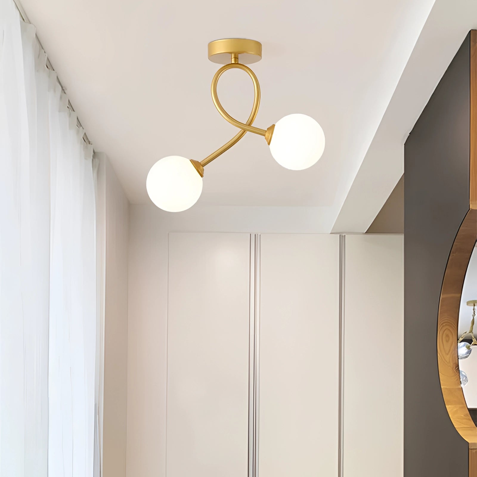 A modern minimalist double globe ceiling light with a black and white fixture and gold accents, elegantly designed for interior spaces. The fixture is mounted on a ceiling, contributing to a sophisticated and contemporary decor style.