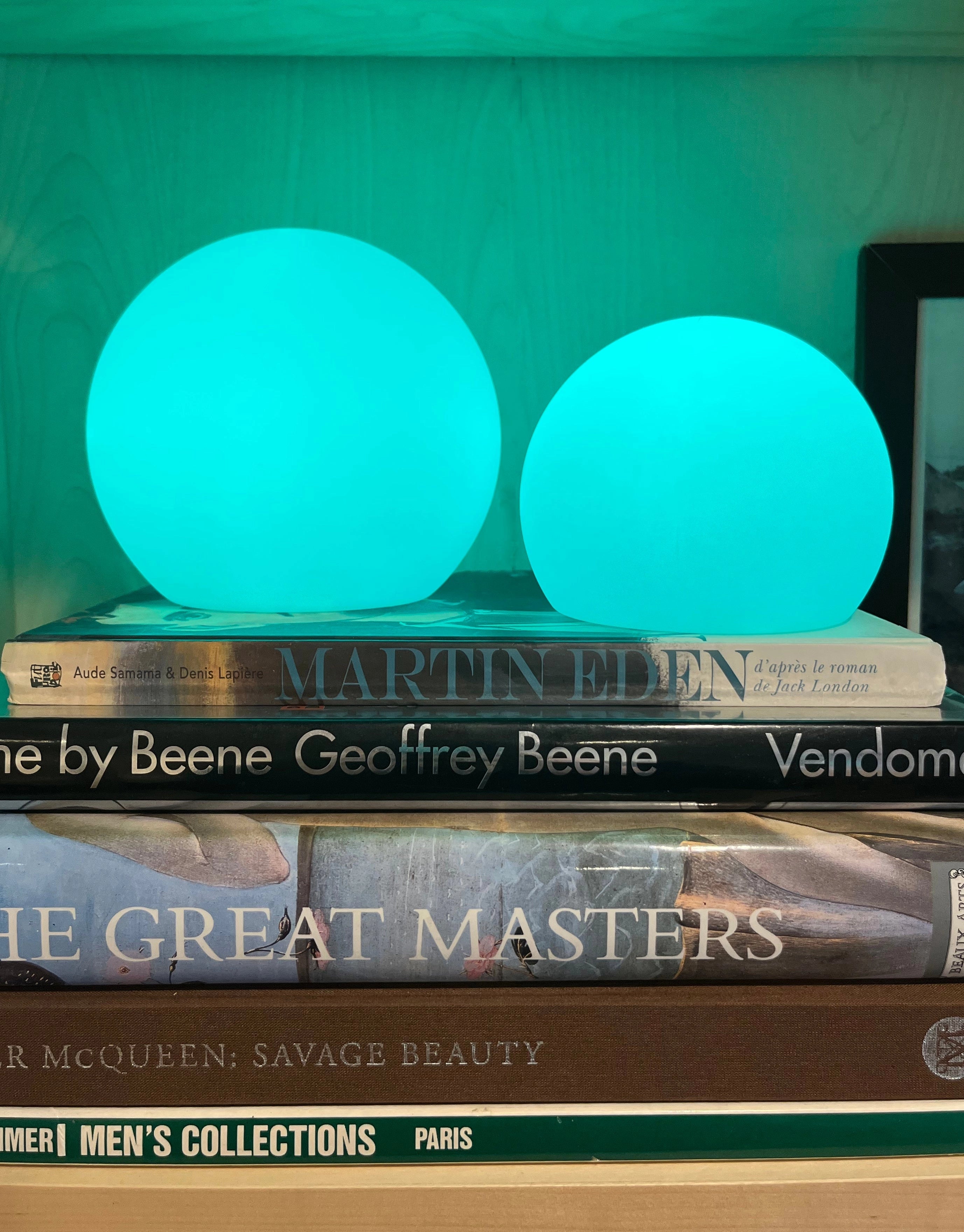 Modern Minimalist LED Globe Lamp on a wooden bedside table in a room with a rectangular book and publication materials nearby.